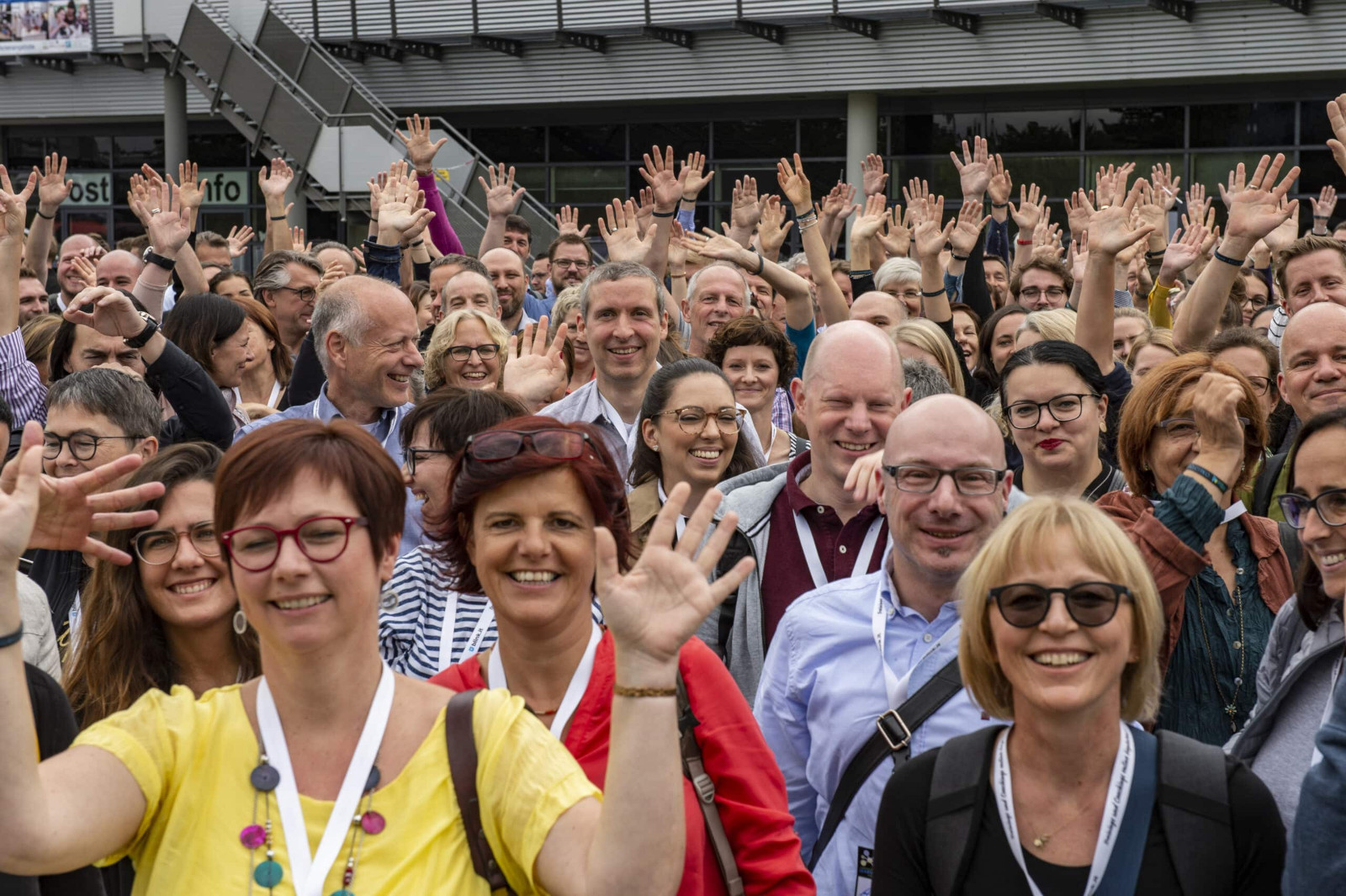 Gruppenfoto auf dem #CLC19ko (Foto von Charlotte Venema). Das Bild stammt von einer Veranstaltung der Corporate Learning Community. Auf dem Bild sind viele fröhliche Menschen zu sehen. Sie stehen dicht beieinander und lächeln. Viele heben die Hände und winken. Die Menschen tragen
Namensschilder.